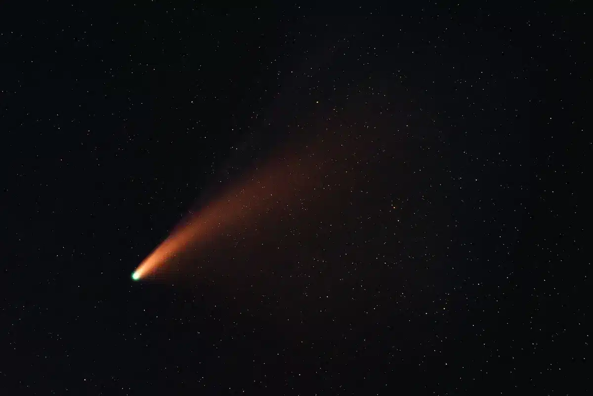 Illustrazione di una cometa con chioma e coda luminosa nello spazio