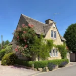 Famiglia con bambini che si trasferisce in una casa di campagna inglese con valigie