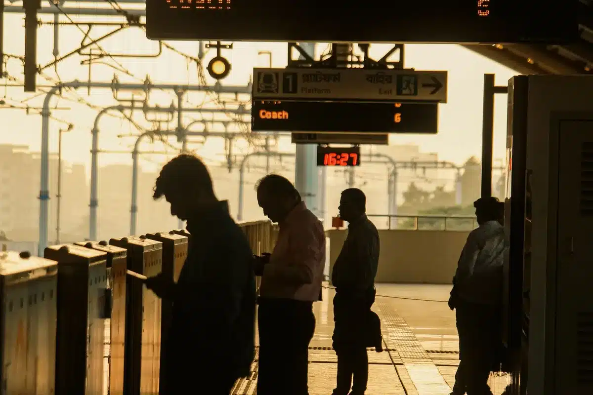 Passeggeri in attesa su una banchina affollata di stazione ferroviaria durante uno sciopero