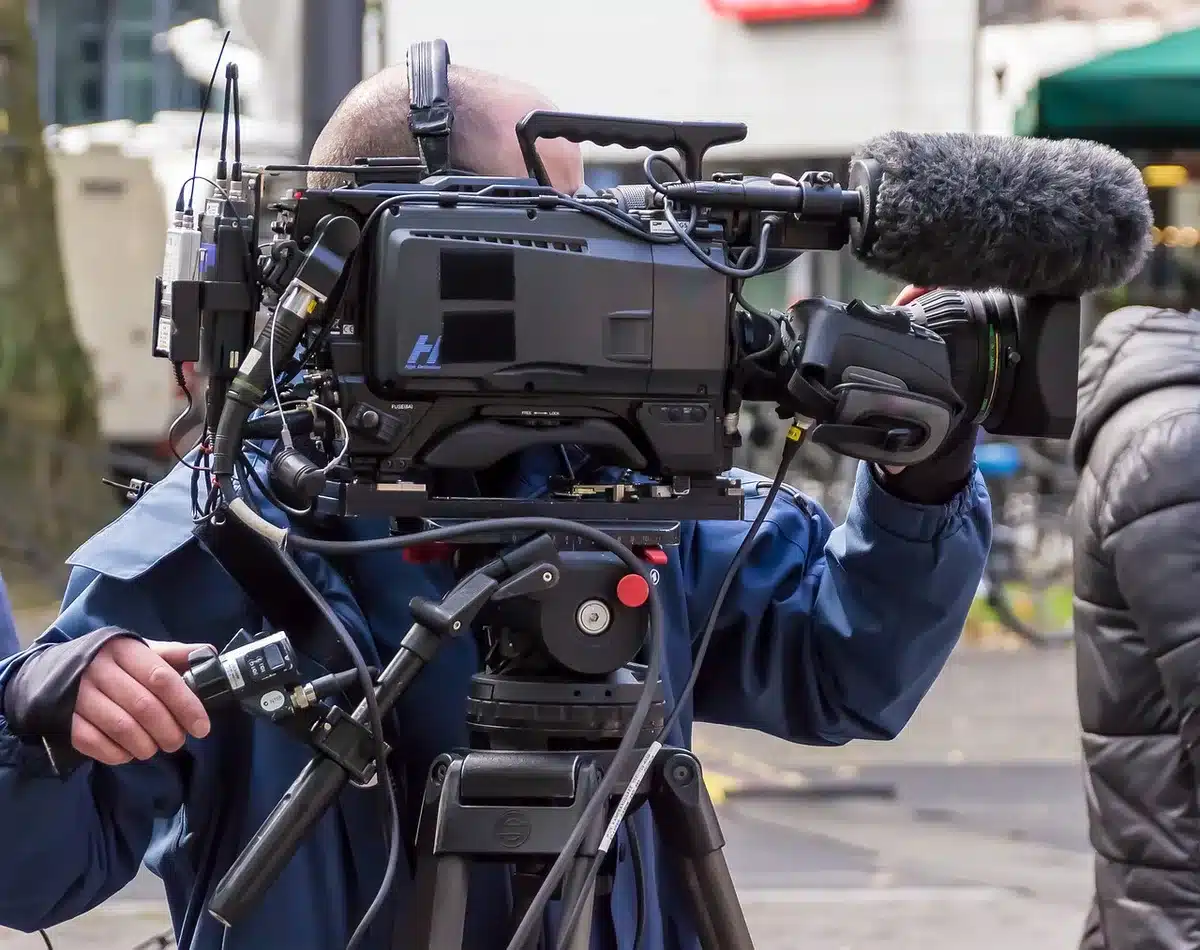 Regista sul set con ciak e luci che rappresenta il lavoro cinematografico e le controversie artistiche
