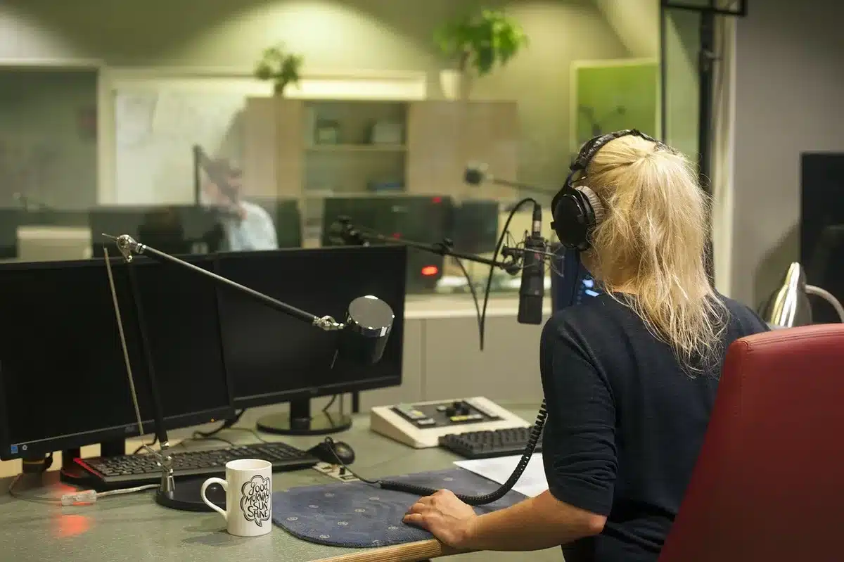 Banco di conduttori e microfoni in uno studio radio durante una diretta