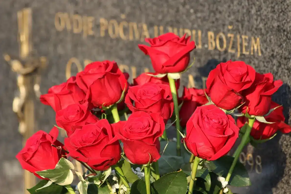 Mano anonima con un bouquet e biglietti di cordoglio su un tavolo nella chiesa