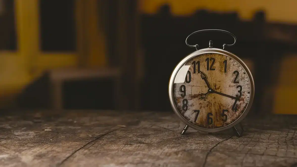 Mani anonime che sistemano capi vintage su un tavolo in legno, atmosfera anni '70