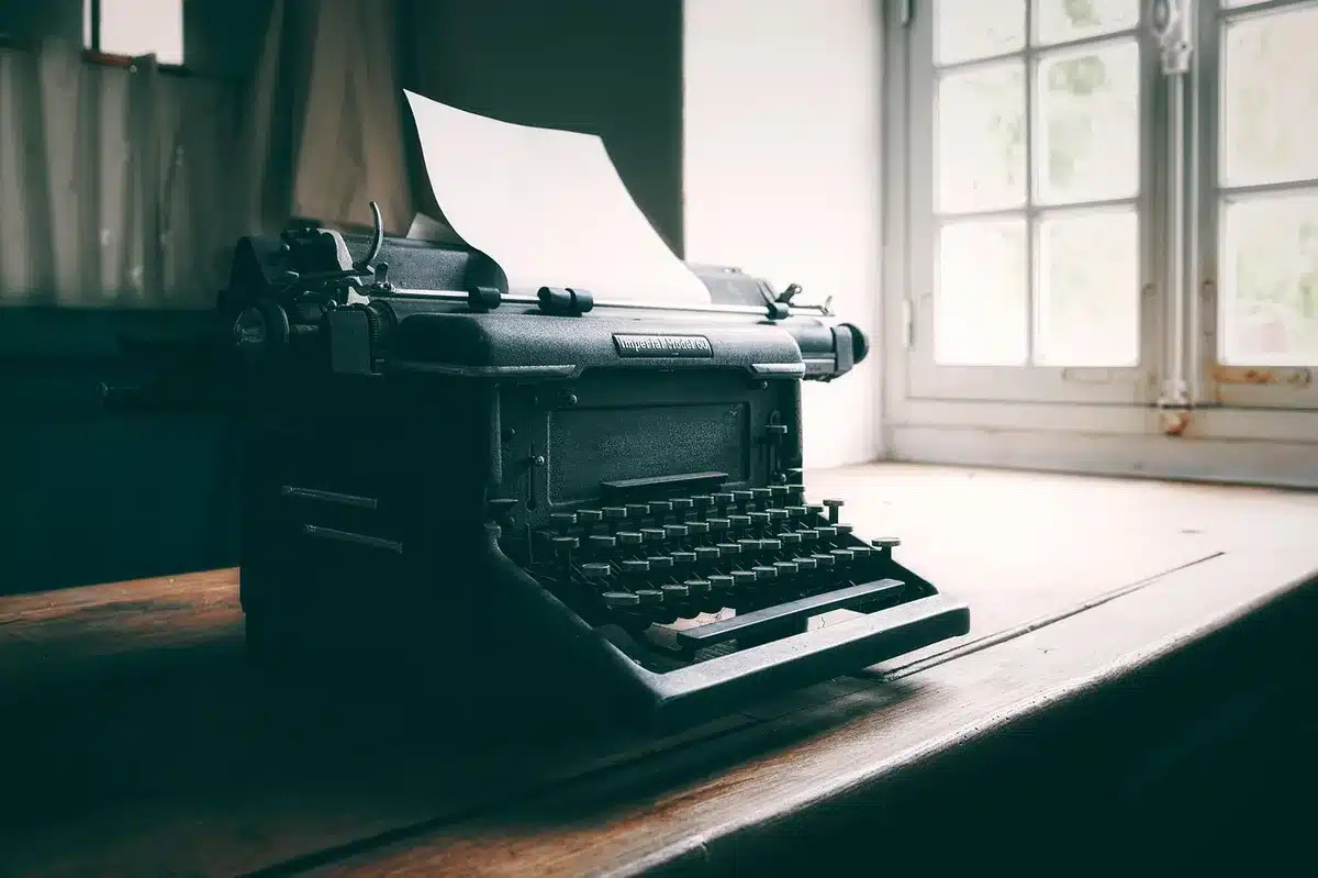 Macchina da scrivere in redazione con giornali su una scrivania