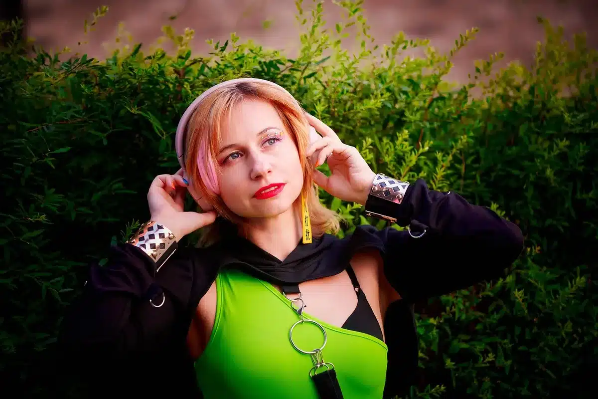 Attrice sul set di un videoclip rock anni Novanta vicino a una motocicletta