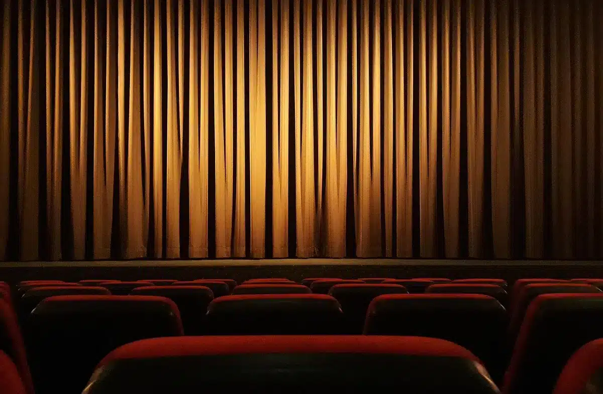 Attore sul palco con gestualità accentuata durante un reading teatrale