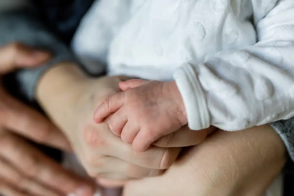 Mani che aiutano una persona anziana a casa, immagine del supporto familiare