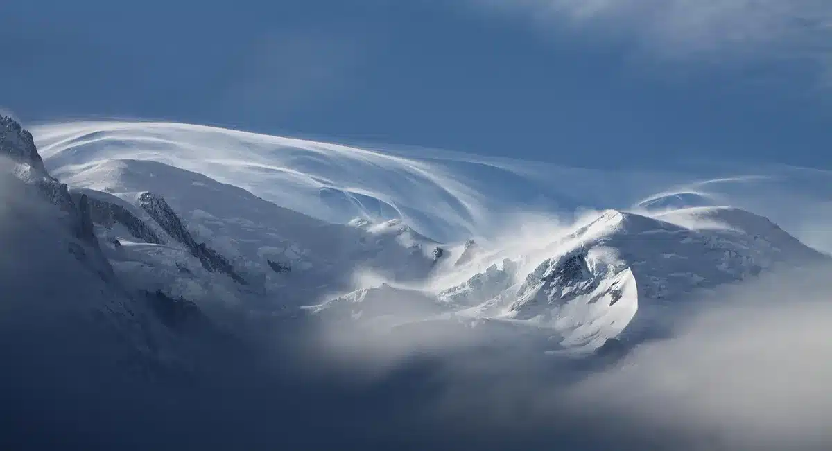 Auto con catene su strada di montagna innevata