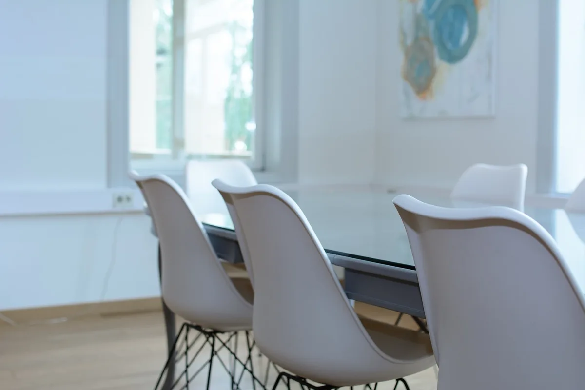 Sala di negoziato vuota con sedie e microfoni dopo i colloqui